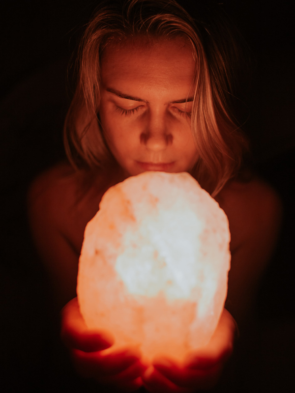 Woman smelling a Himalayan salt lamp