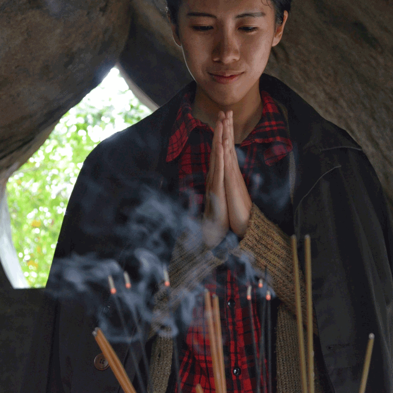 Man praying in front of incense