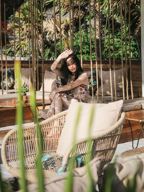 Woman sitting outside near wicker chair