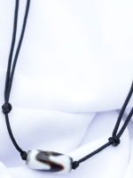 Handcrafted Tibetan Dzi bead bracelet and necklace set with black adjustable cords, displayed on a white fabric background.