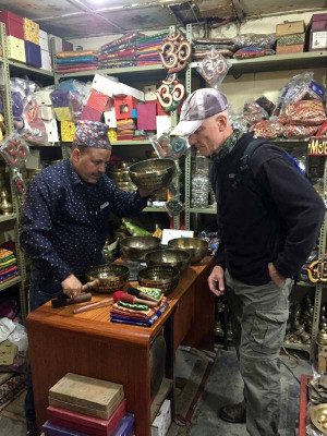 Tibetan singing bowl on a cushion with a wooden stricker