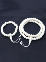 Handcrafted yak bone mala bead set with a wrist mala and 108-bead mala necklace, made in Kathmandu, displayed on a black fabric background.